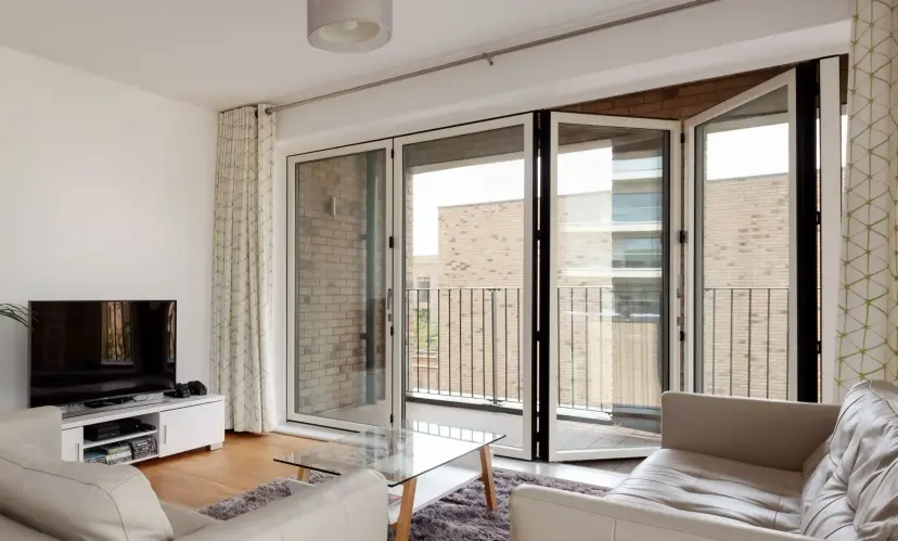bigstock_cambridge_england__aug____441707579_dt20ajd8a6qx9h94kyo6h_1920x1157_7purehsmhplfk9r04rizs6-1920x1157 Living room with glass folding doors opening to a balcony