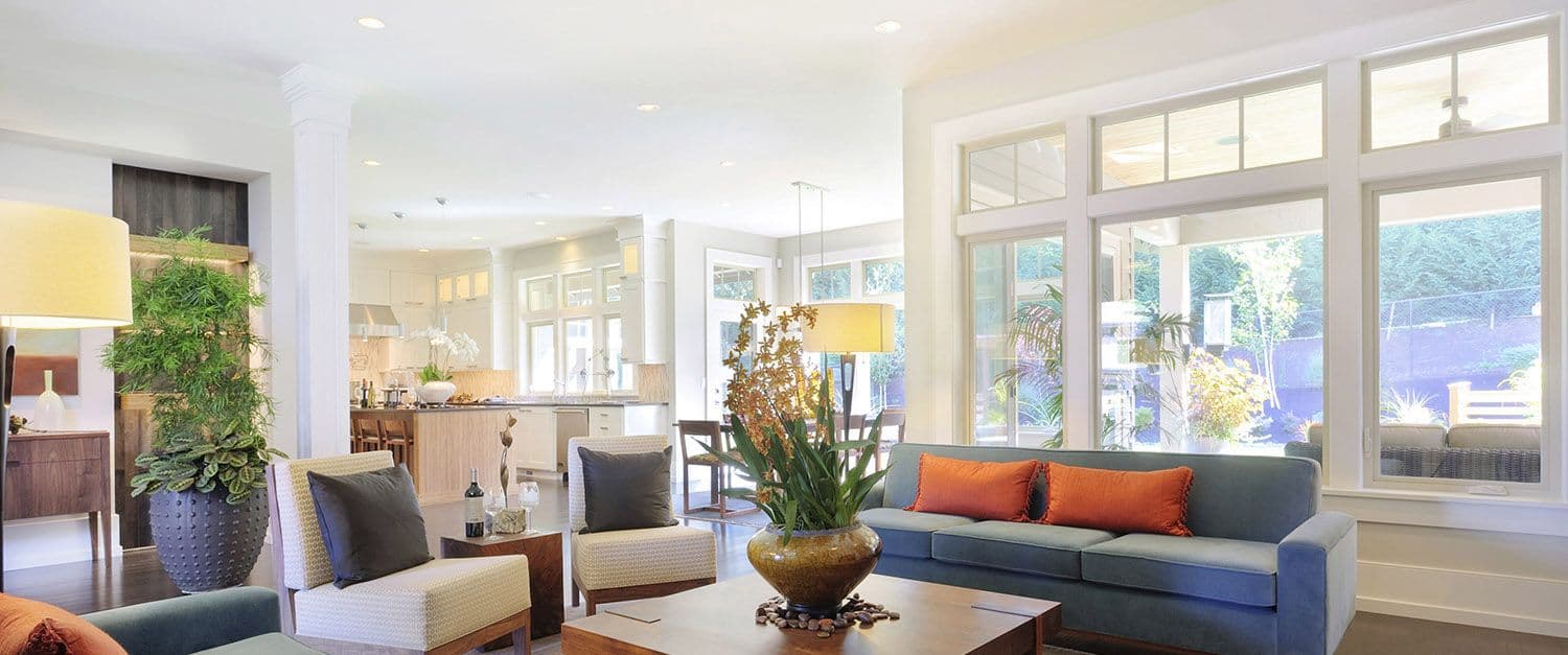 replacement_windows_hero35_dcqsaggix2evl6tpdaxj-1500x627 Bright, modern living room with an open layout leading into a white kitchen