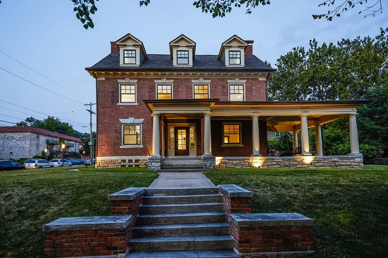 revive__bronze_claddh_ds_pocket_windows_buildertbd_kansascity_mo_2018_66_t0u0qozo2d9u1v17bul92c-1280x850 A stately two-story brick house with three dormer windows on the roof